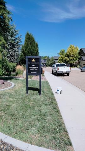 Top Tier Realty listing sign on a black two post frame