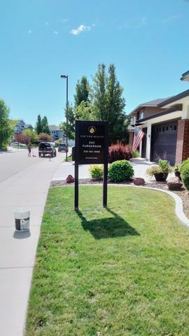 Top Tier Realty listing sign on a black two post frame