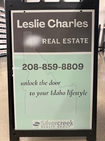 Leslie Charles Real Estate panel in a black A frame